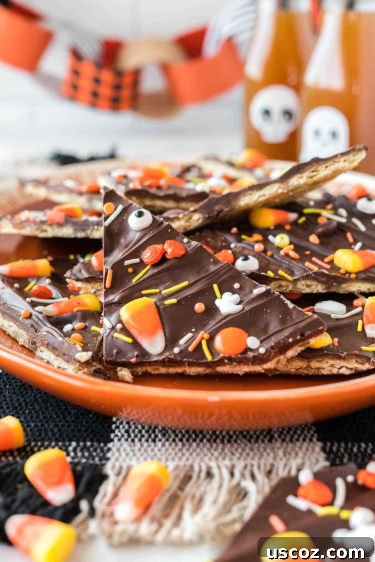 Spooky Halloween Crack 16 Close-up of Halloween crack candy on an orange serving plate, highlighting the textures and toppings.