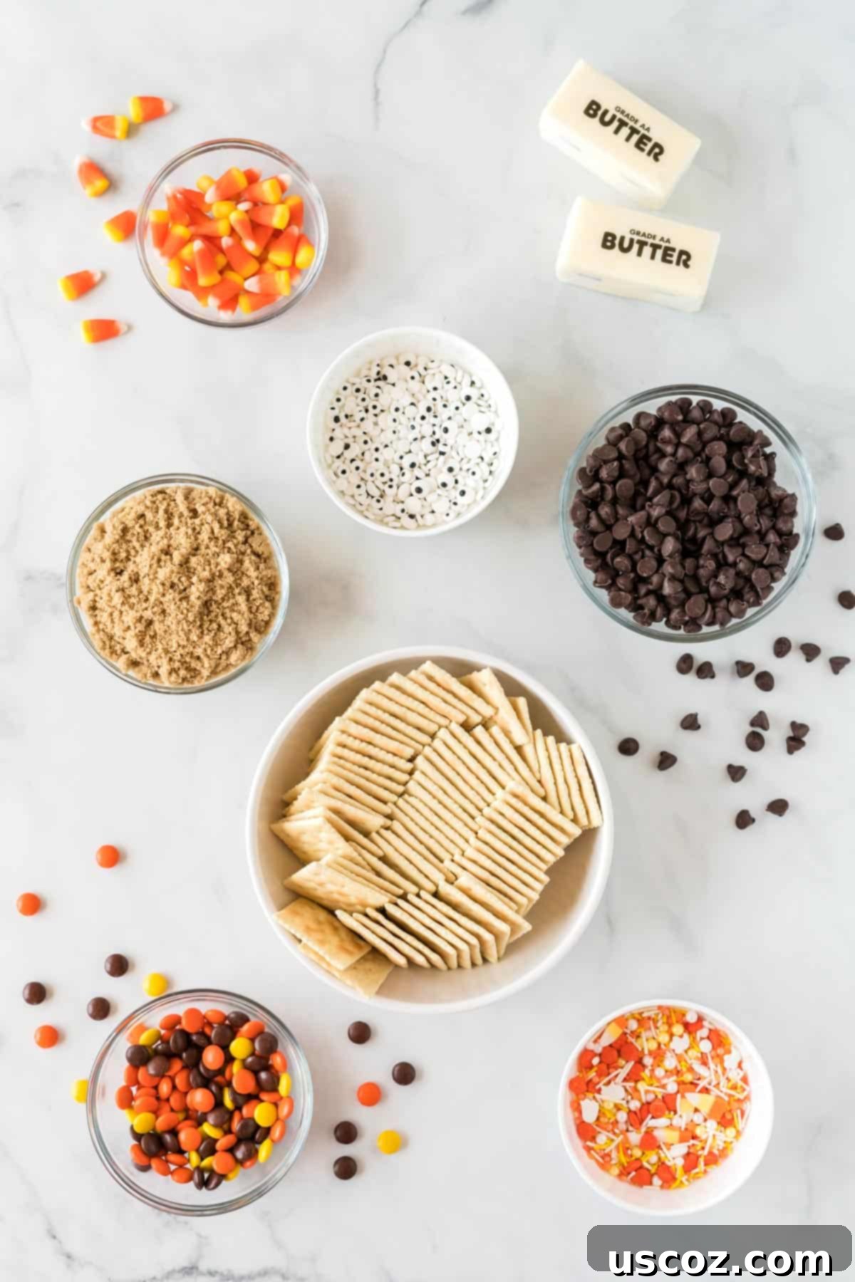 Spooky Halloween Crack 3 Ingredients needed to make Halloween crack candy, including saltines, chocolate, butter, brown sugar, and various spooky candies.