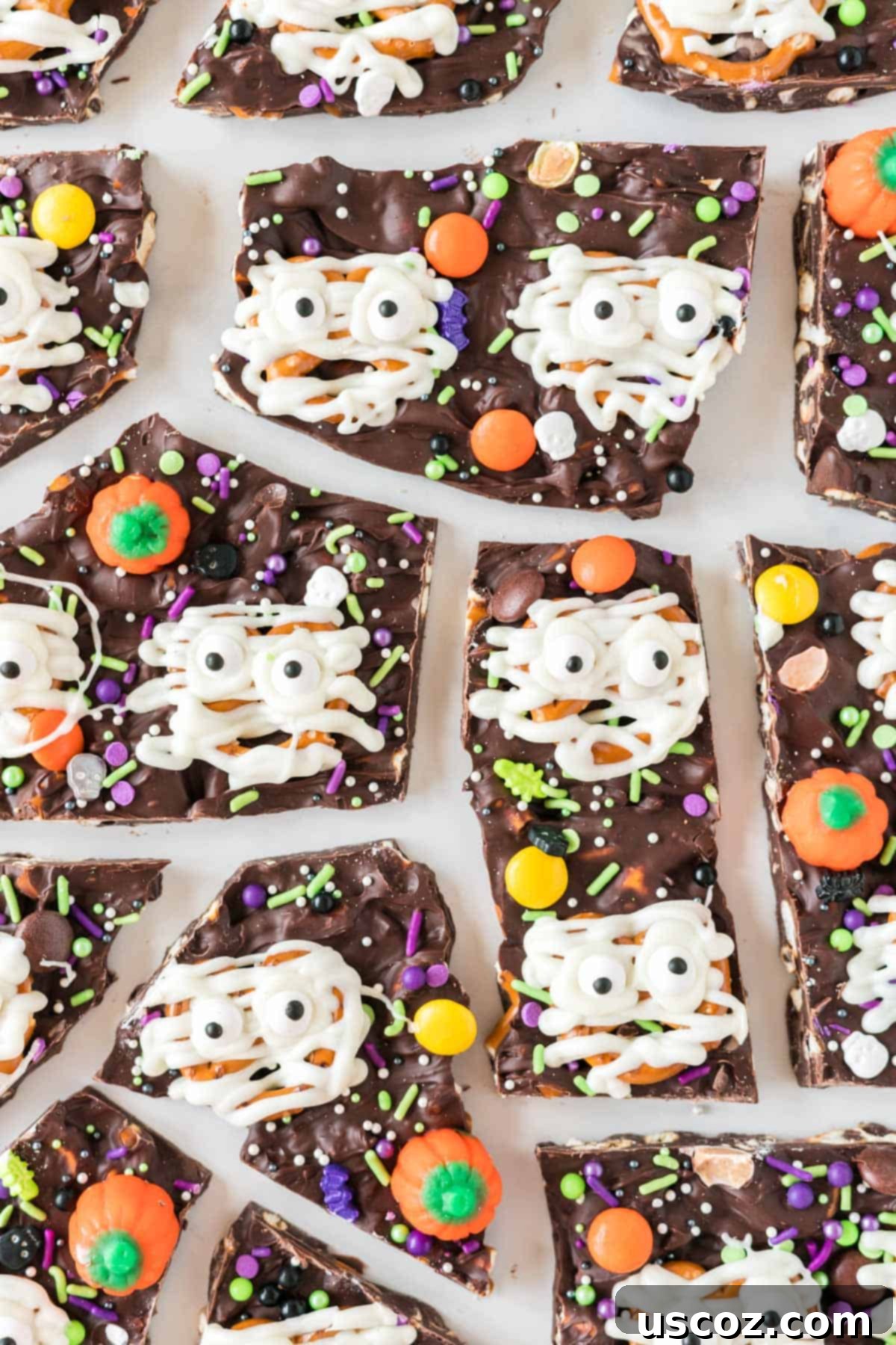 Monster Mash Bark 2 halloween bark broken into pieces, showcasing the different candies and pretzel mummies