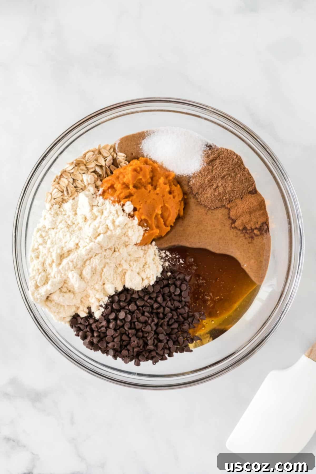 Pumpkin Protein Bites 5 Mixing bowl with pumpkin protein ball ingredients being stirred with a spatula