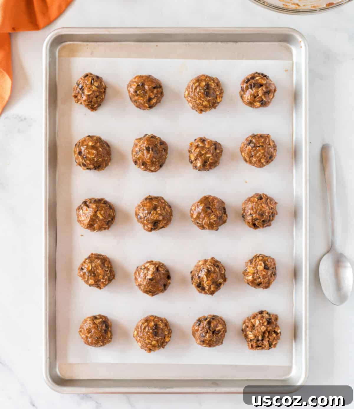 Pumpkin Protein Bites 8 Pumpkin protein balls neatly lined up on a baking sheet, ready for chilling