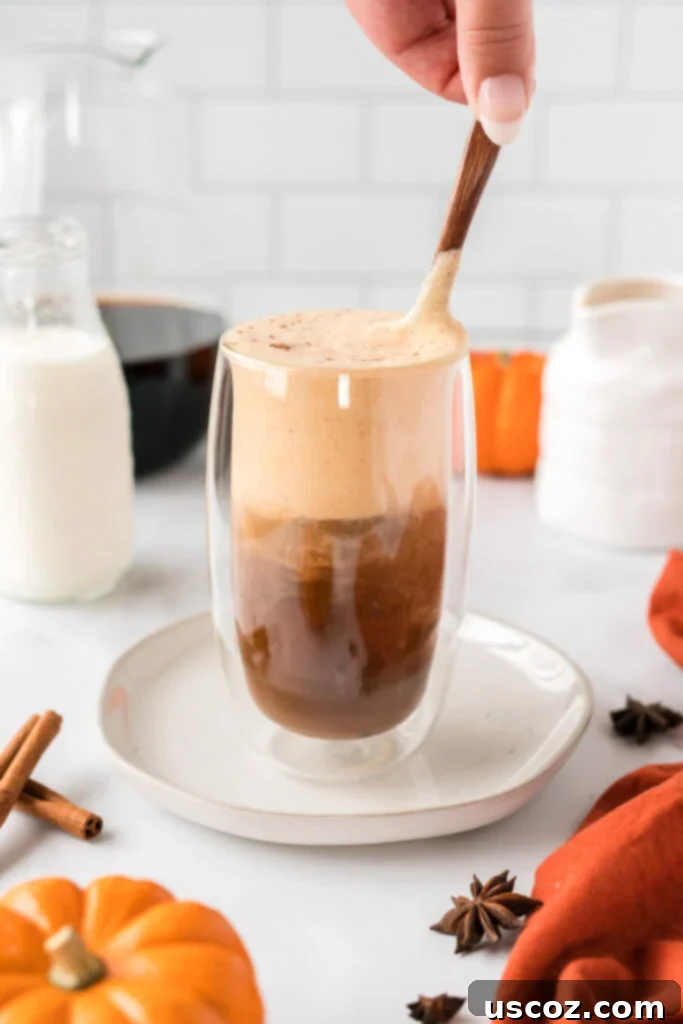 Spiced Pumpkin Cold Brew 10 A spoon mixing the pumpkin cream into the cold brew coffee, creating a smooth, blended drink