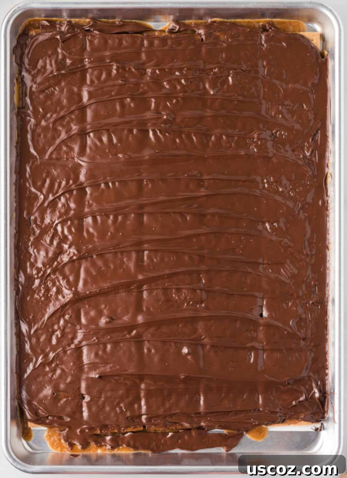 Golden Graham Toffee 12 spreading out the melted chocolate smoothly over the toffee layer