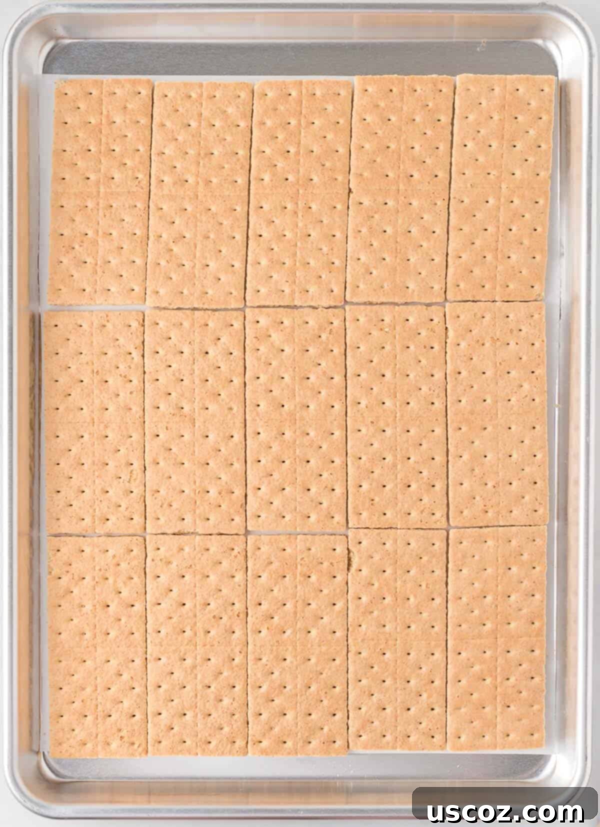 Golden Graham Toffee 5 graham crackers lined up neatly on a parchment-lined baking sheet