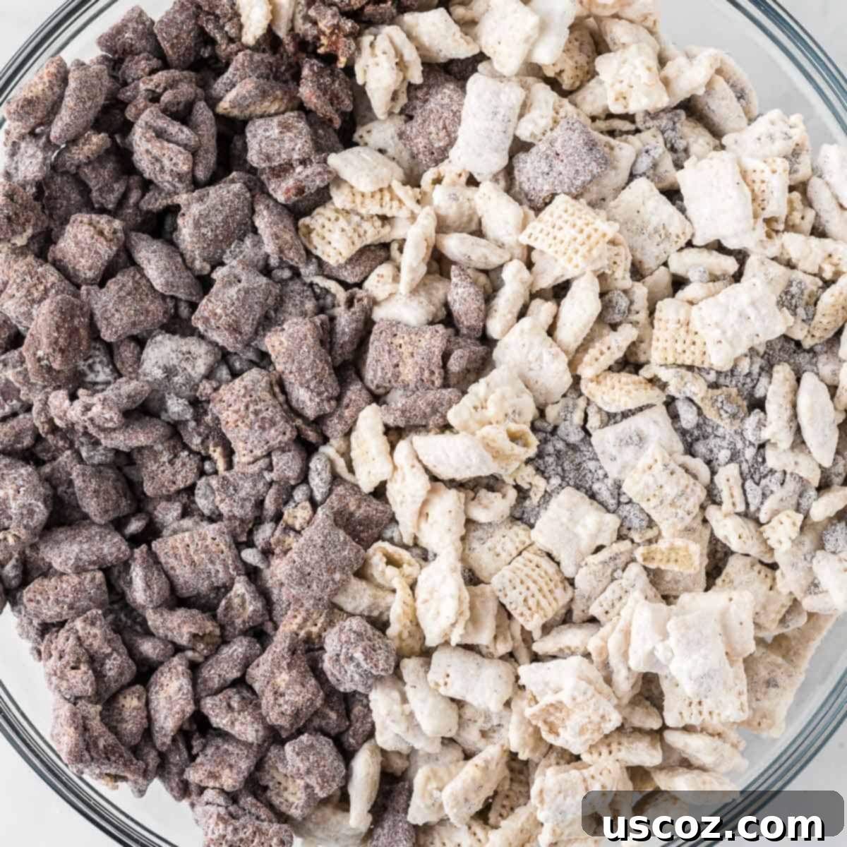 Cookies and Cream Dream Bites 2 A large serving bowl filled with delicious Cookies and Cream Muddy Buddies, showcasing the mix of white and dark chocolate coated Chex cereal with crushed Oreo pieces.