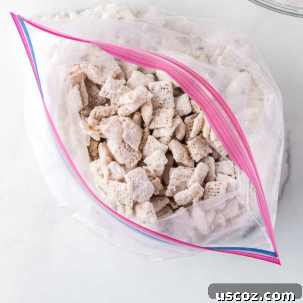 Cookies and Cream Dream Bites 12 White chocolate muddy buddies, perfectly coated with powdered sugar and crushed Oreos, visible inside a ziploc bag.