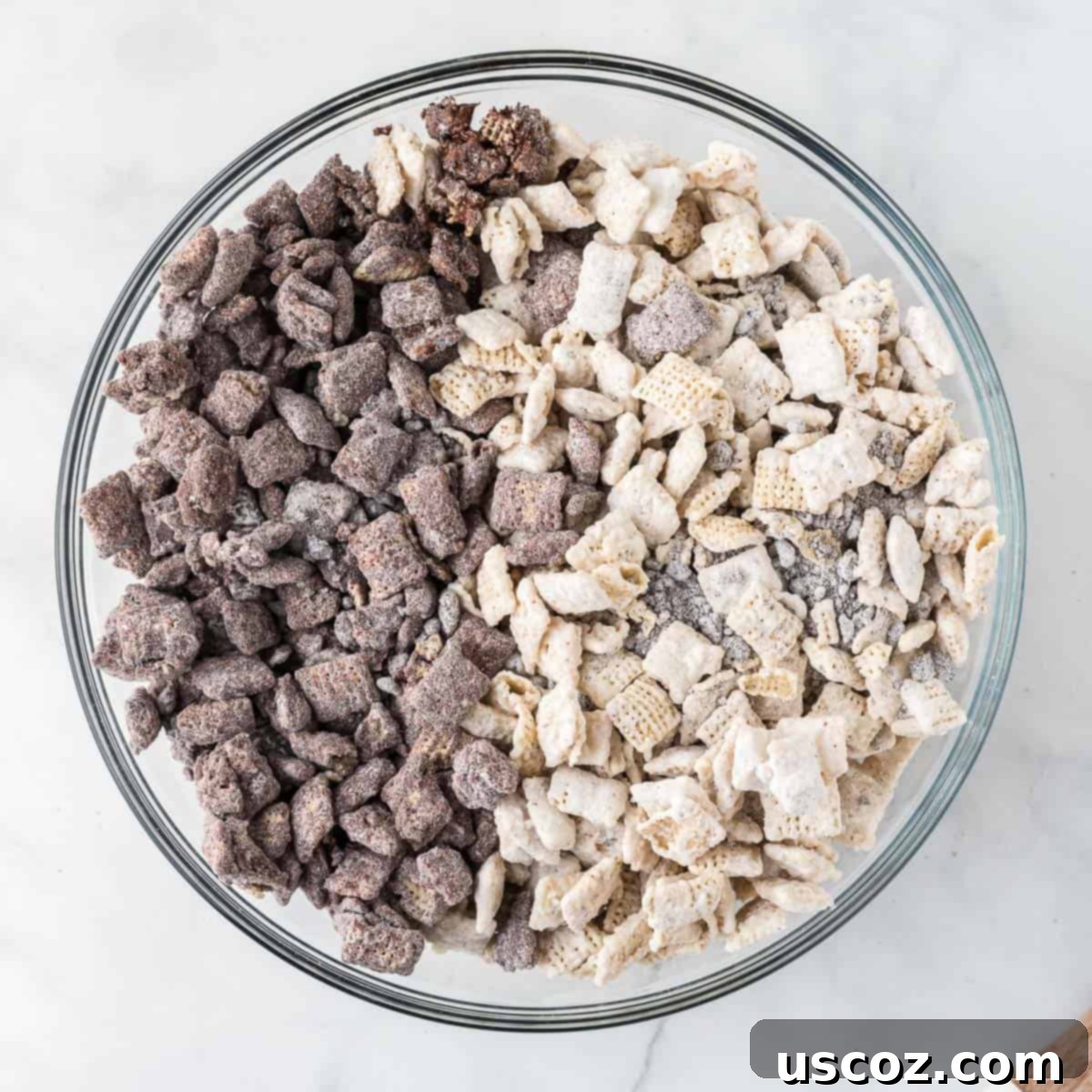 Cookies and Cream Dream Bites 13 A large serving bowl showcasing the delightful combination of both chocolate and white chocolate muddy buddies, mixed together to create the cookies and cream effect.