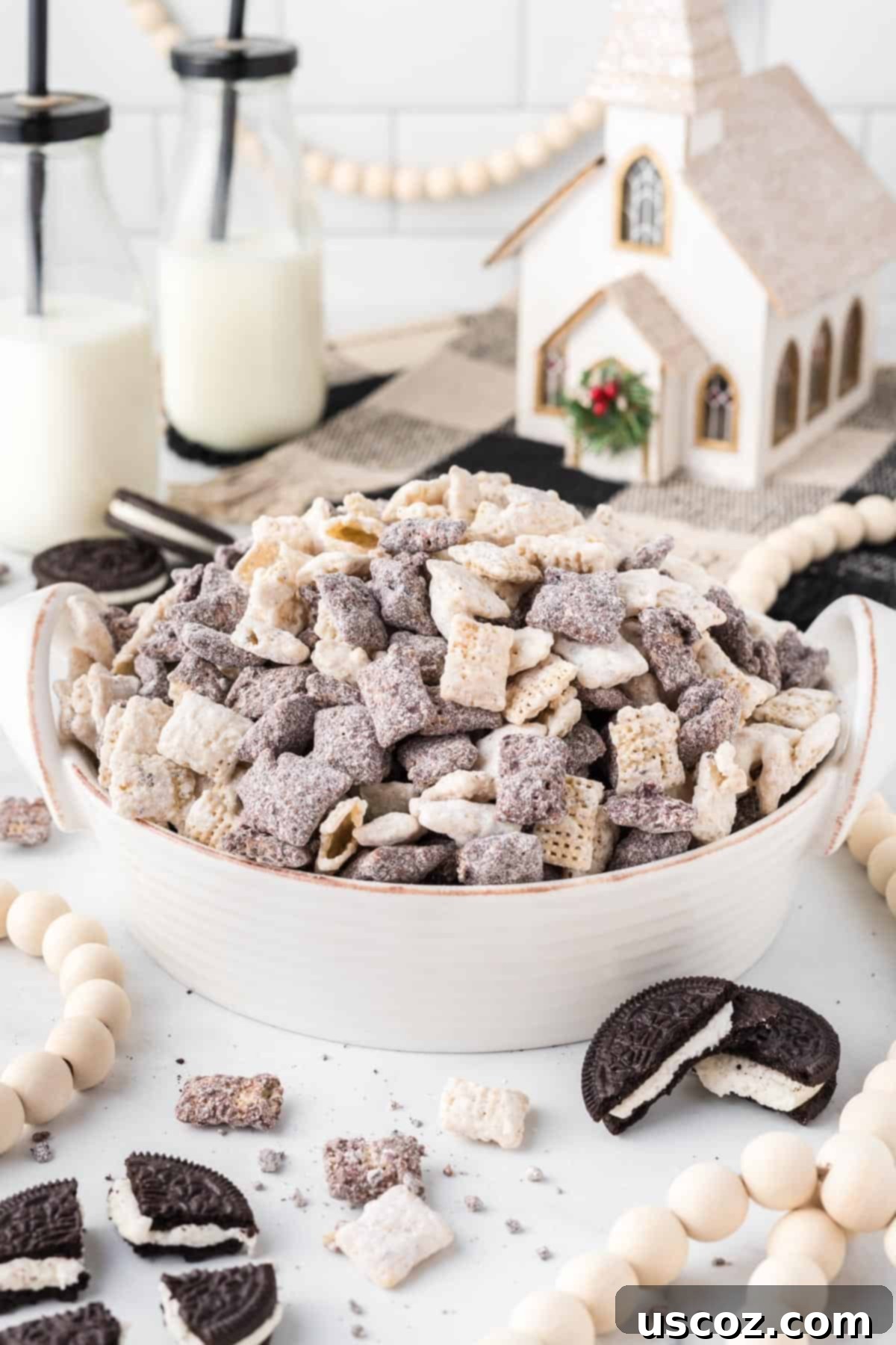 Cookies and Cream Dream Bites 16 A festive holiday setup featuring a large bowl of Cookies and Cream Muddy Buddies, surrounded by subtle Christmas decor, creating a warm and inviting atmosphere.