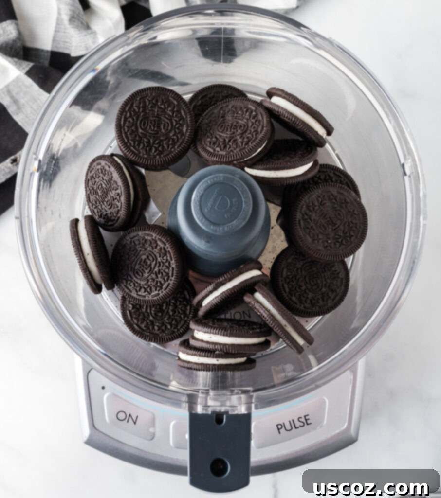 Cookies and Cream Dream Bites 5 Whole Oreo cookies being added to a food processor bowl, ready to be crushed.