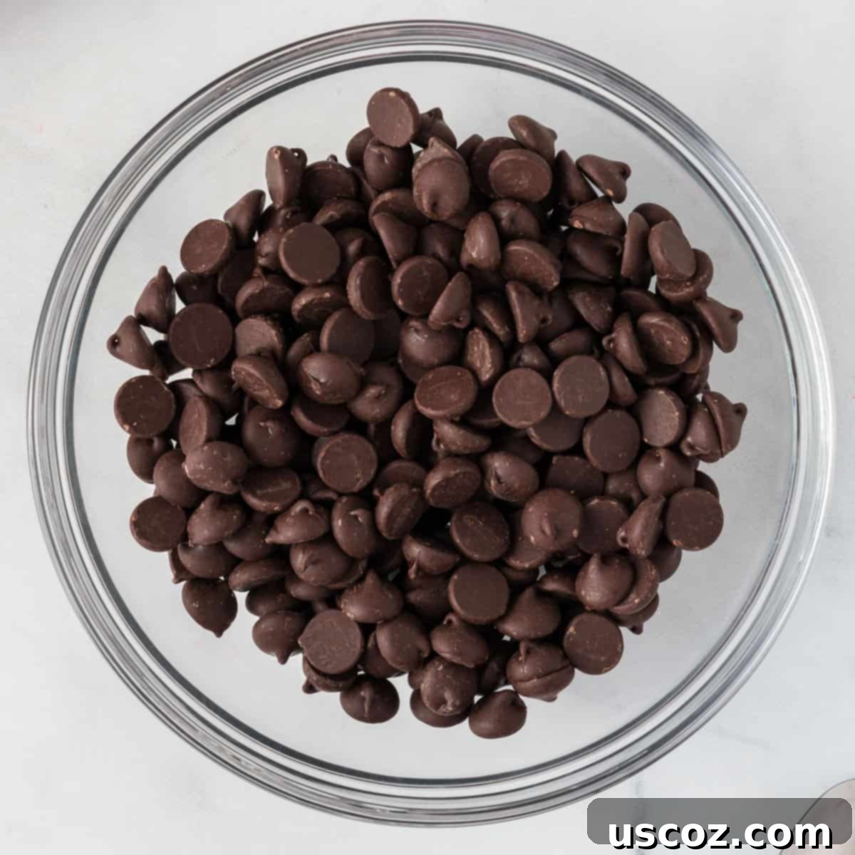 Decadent Mint Chocolate Bark 5 Dark chocolate chips in a bowl, ready for melting to create the base layer of peppermint bark.