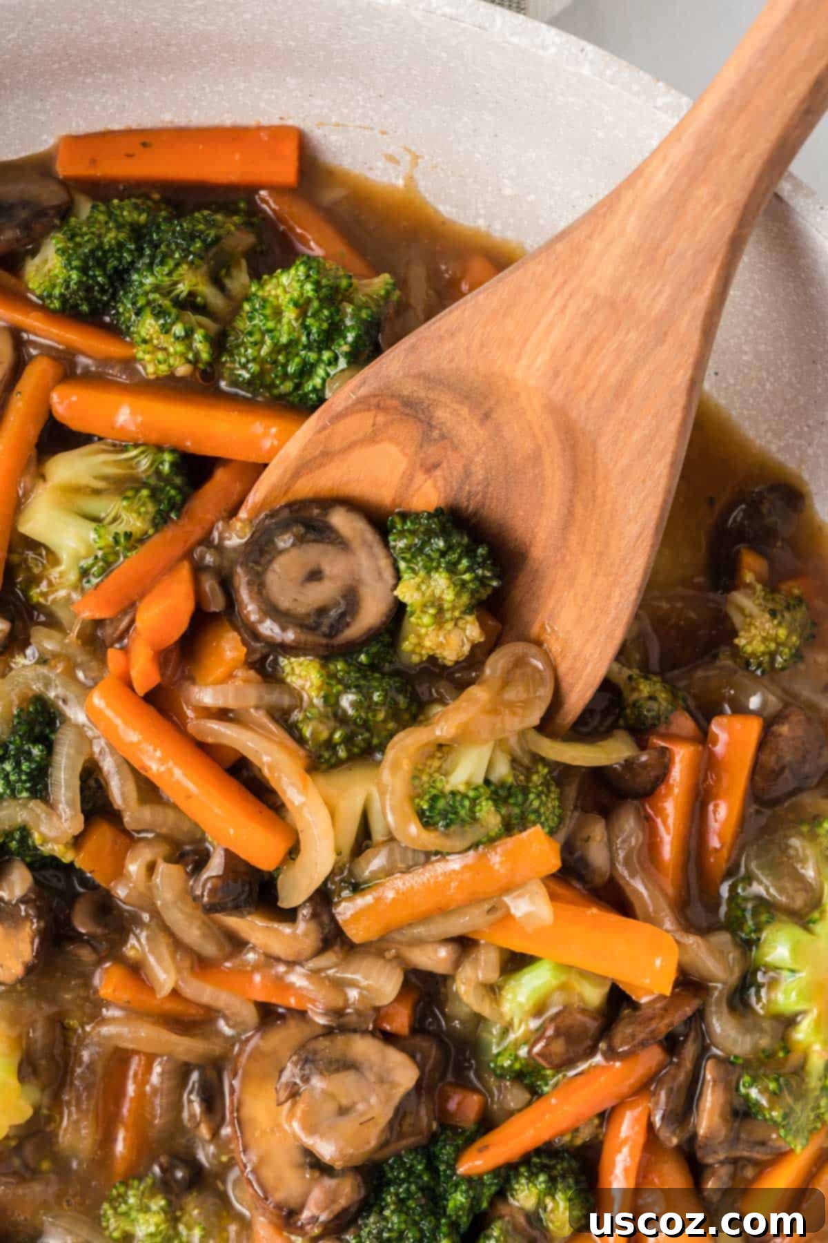 Sizzling Teriyaki Harvest 11 wooden spoon taking a serving of teriyaki vegetables