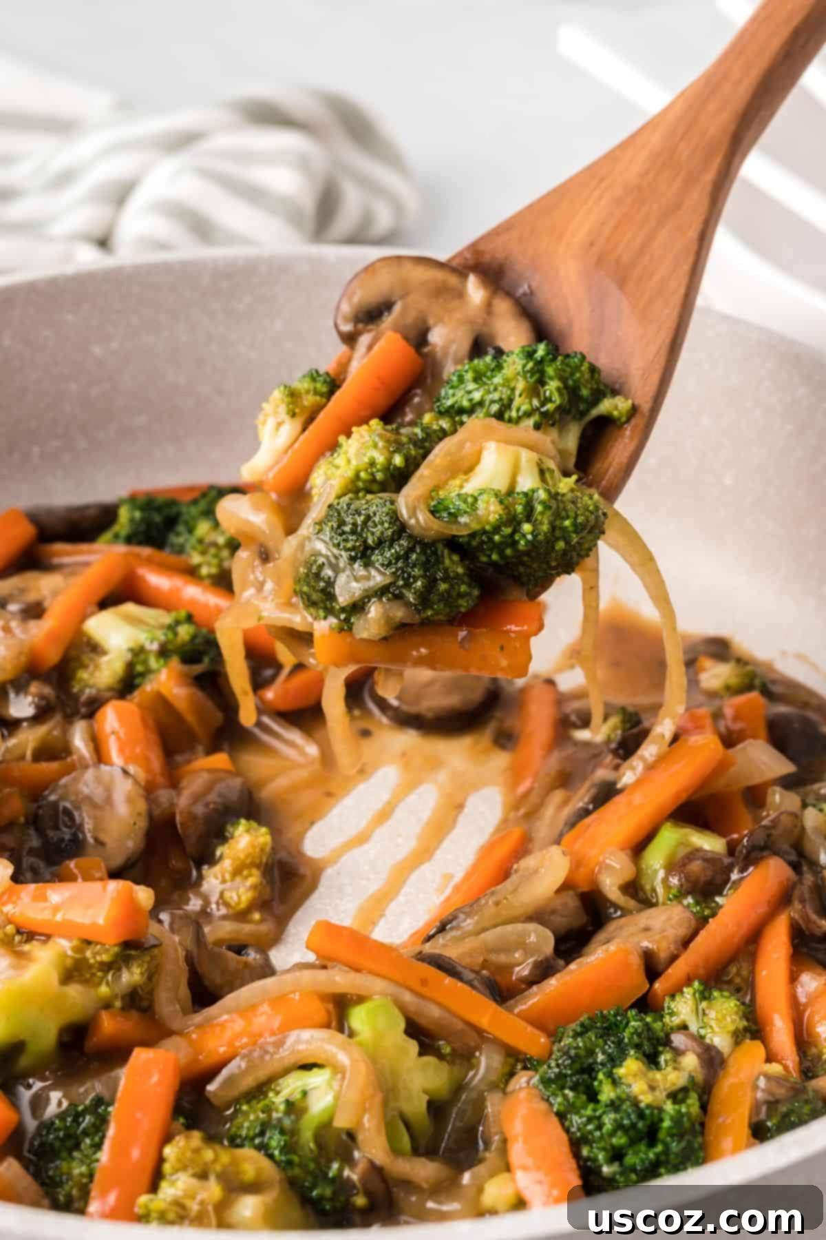 Sizzling Teriyaki Harvest 9 wooden spoon taking a serving of teriyaki vegetables
