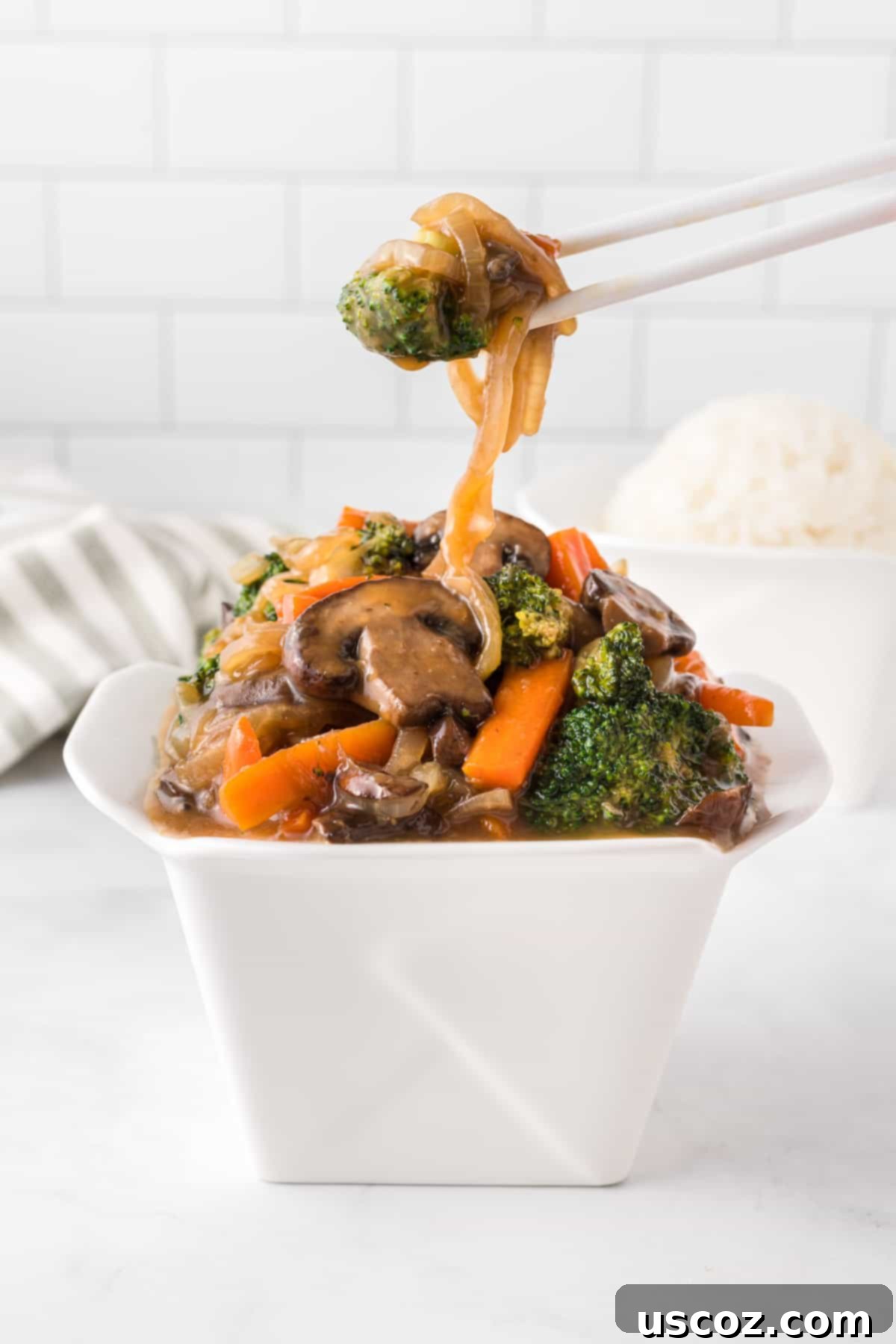 Sizzling Teriyaki Harvest 10 chopsticks taking teriyaki vegetables from a takeout container