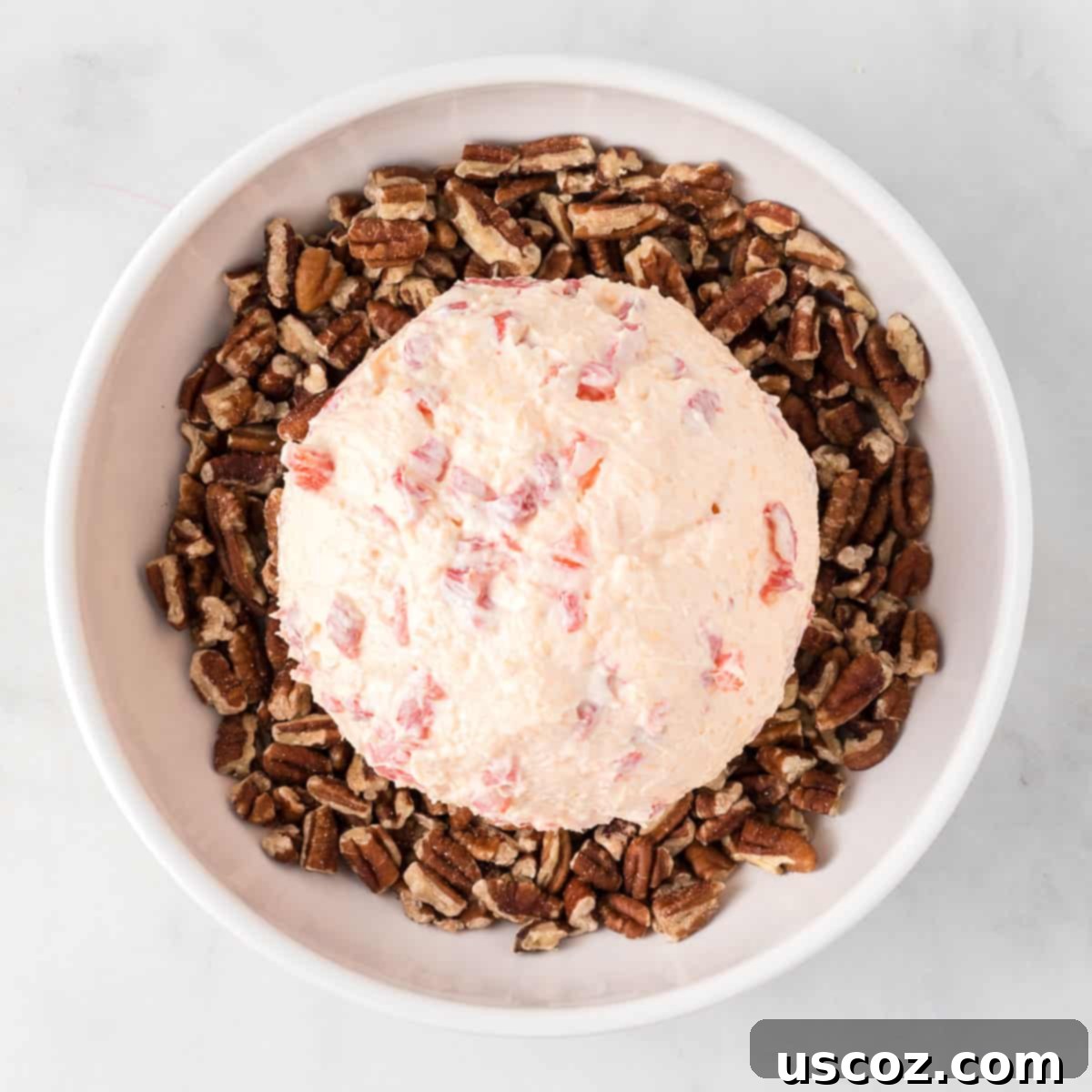 Classic Pimento Cheese Ball 11 cheese ball over a bowl of pecan pieces