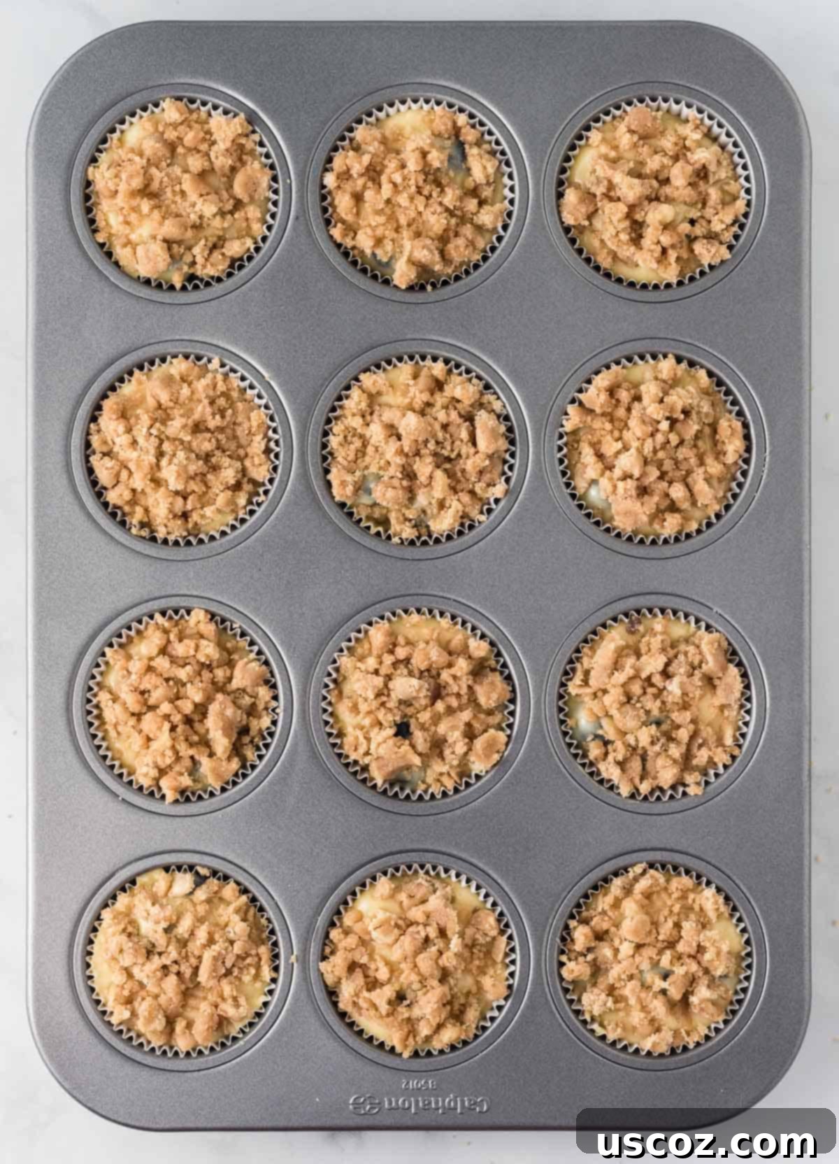 Effortless Cake Mix Blueberry Muffins 14 Adding the streusel topping generously over the muffin batter