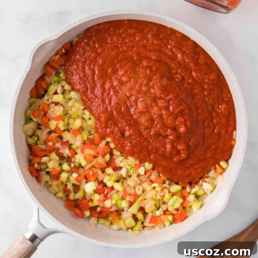 Cheesy Meatless Ziti Bake 7 Adding rich pasta sauce to the sautéed vegetables in a skillet
