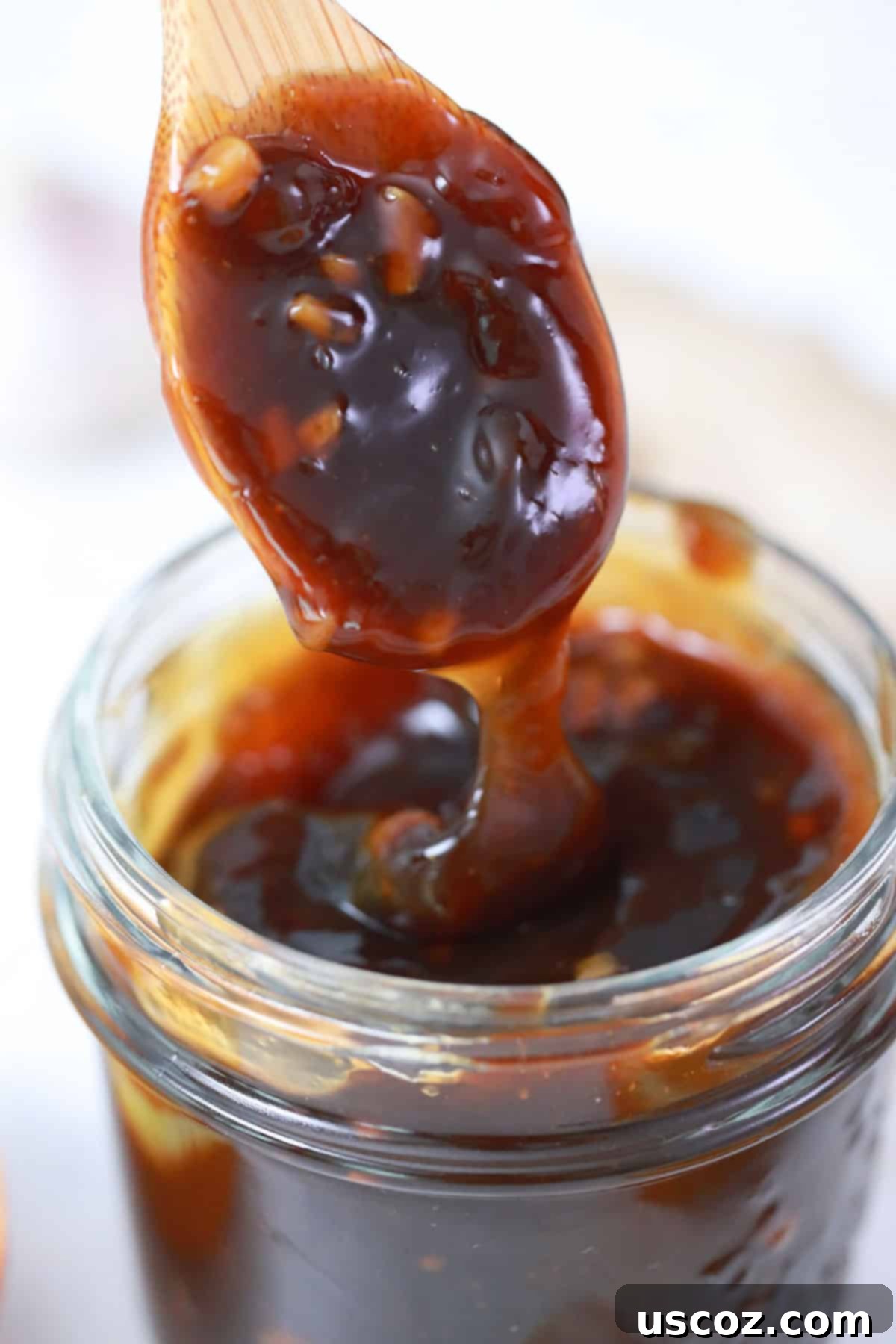 Glazed Teriyaki Mushrooms 7 A wooden spoon dripping glossy, homemade teriyaki sauce, highlighting its perfect consistency.