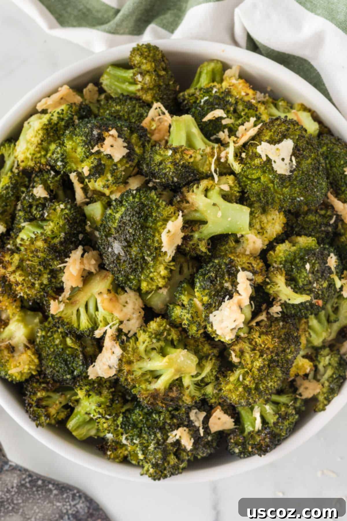 Parmesan Roasted Broccoli 12 A bowl filled with freshly roasted broccoli florets topped with melted parmesan cheese, ready to serve