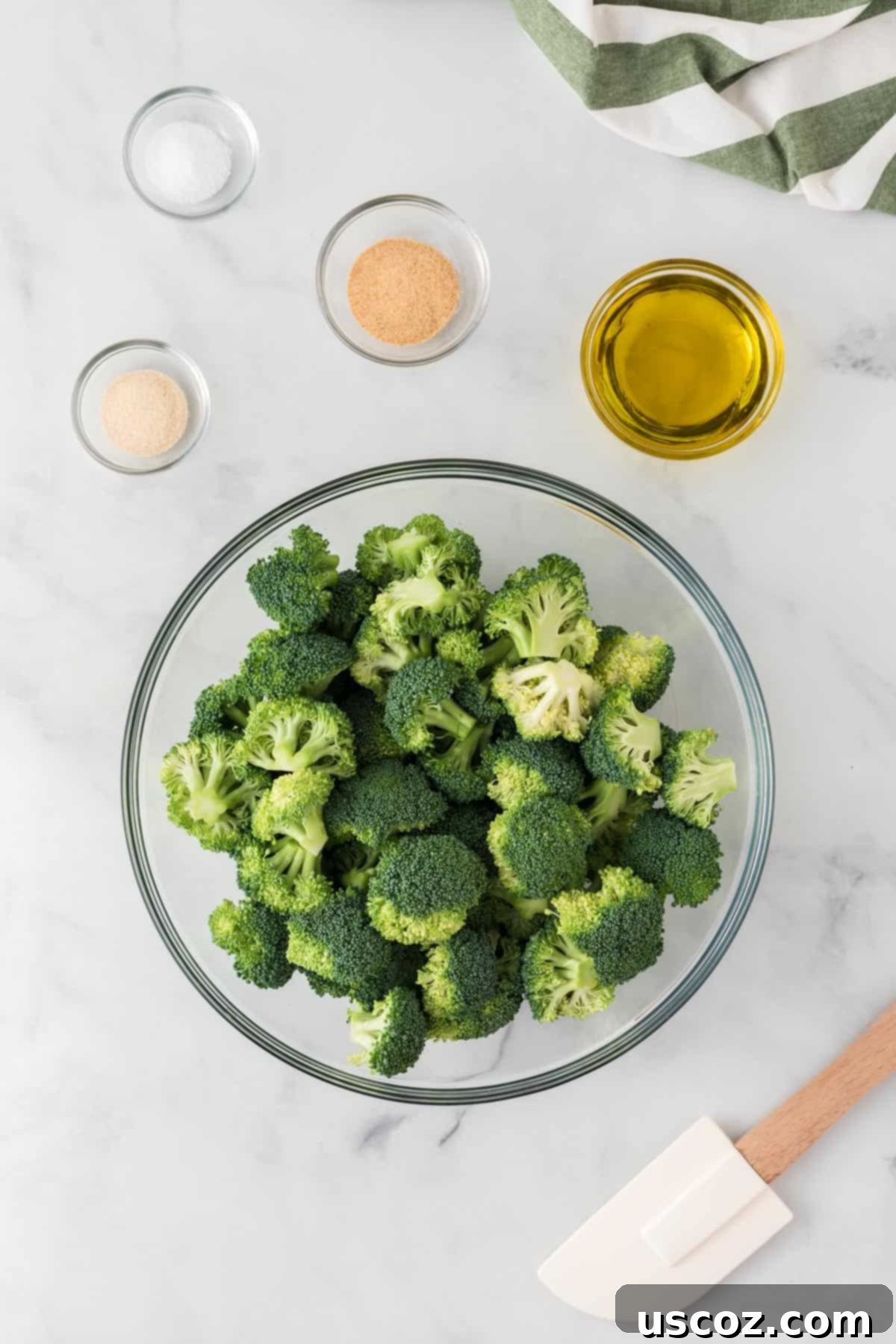 Parmesan Roasted Broccoli 5 Broccoli florets neatly arranged next to a bowl of olive oil and spices