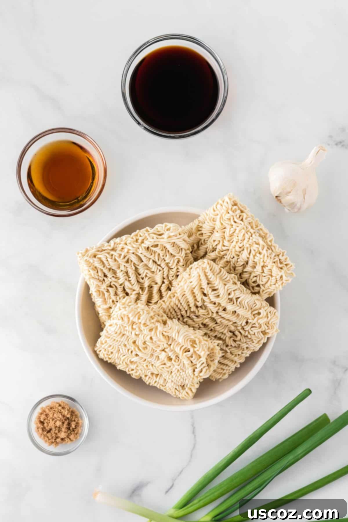 Easy Sesame Garlic Ramen 4 A trio of ingredients – fresh minced garlic, rich sesame oil, sweet brown sugar, and savory soy sauce – laid out with ramen noodles, ready for assembly into a delicious meal.