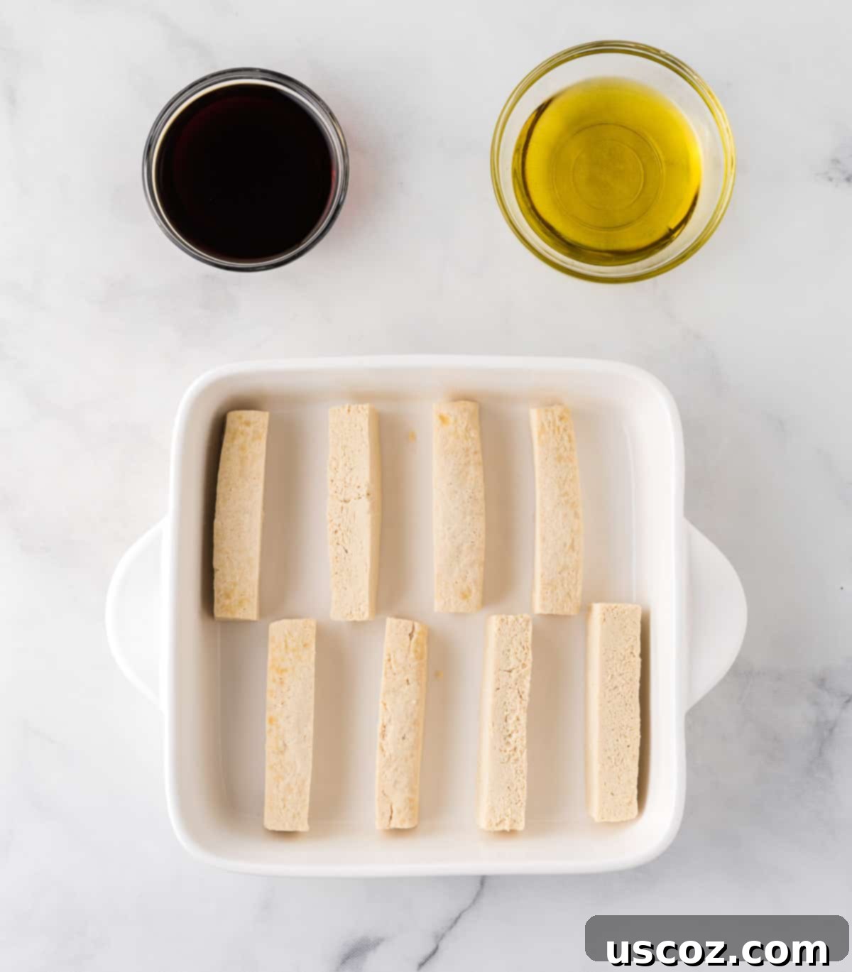 Savory Tofu Wraps 8 tofu blocks in a baking dish next to soy sauce and olive oil