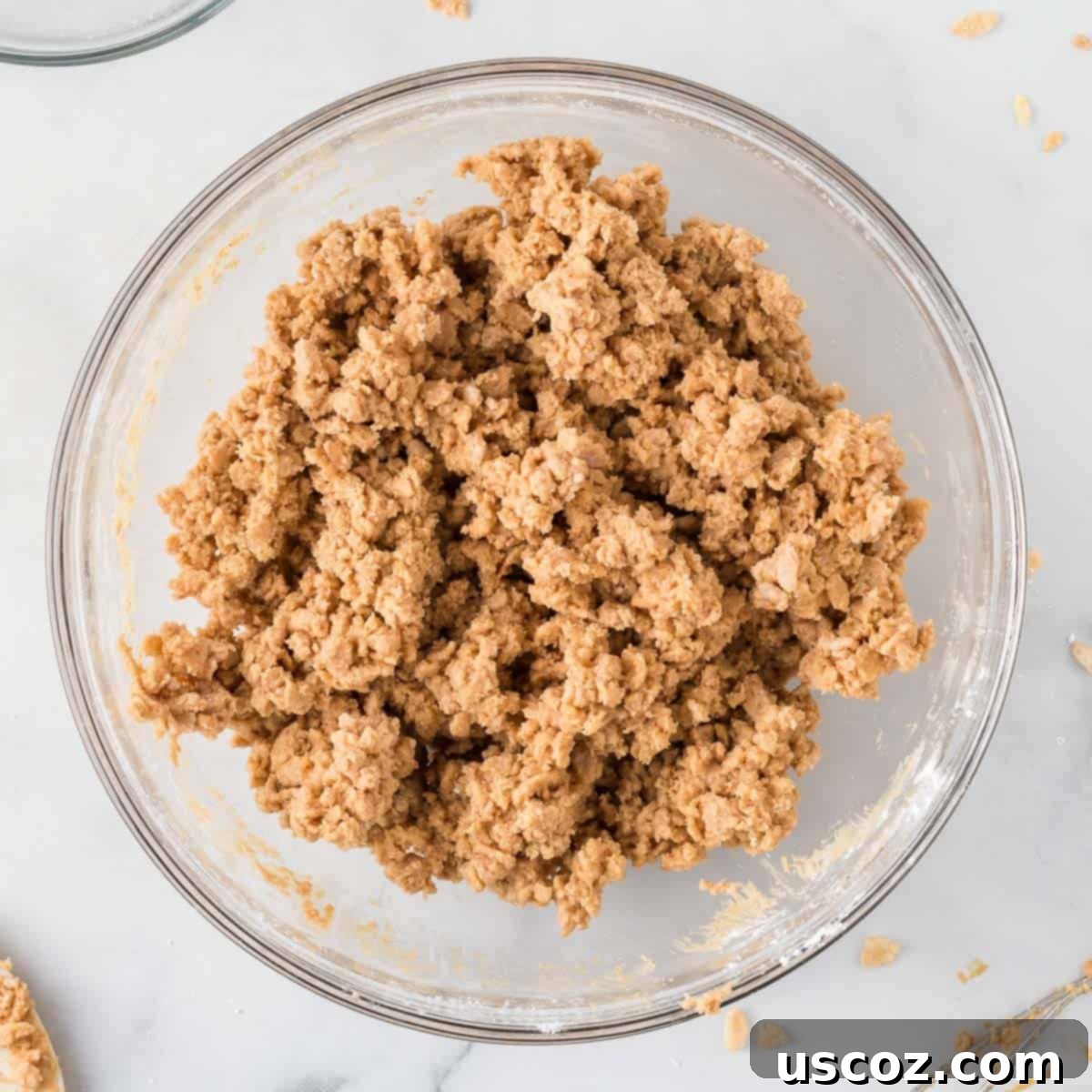 No-Bake Peanut Butter Krispie Treats 6 A bowl filled with a combined mixture of peanut butter, Rice Krispies, and powdered sugar, showing the sticky, yet firm texture.