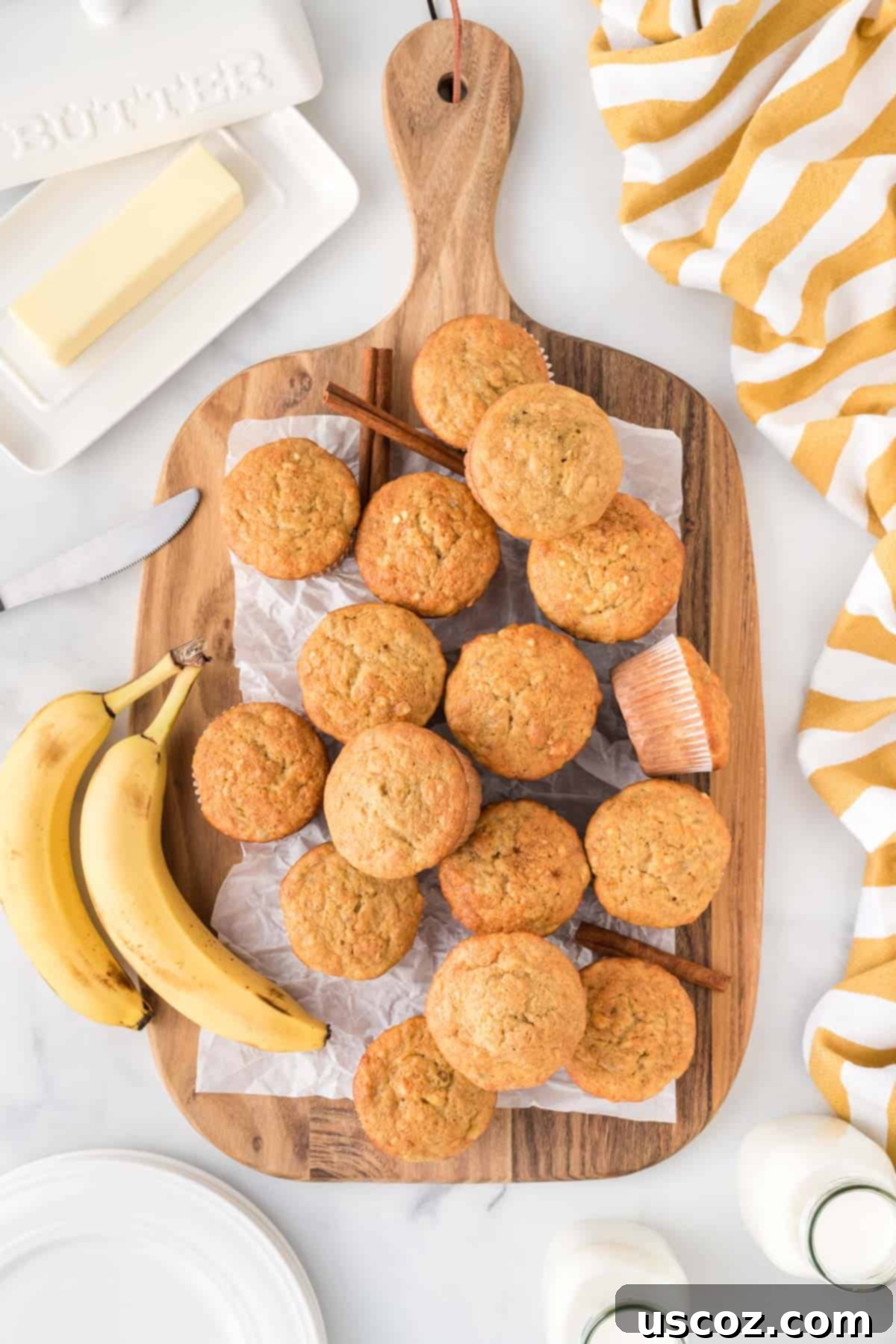 Easy Cake Mix Banana Muffins 13 Freshly baked cake mix banana muffins displayed on a rustic wooden cutting board, ready to be served.