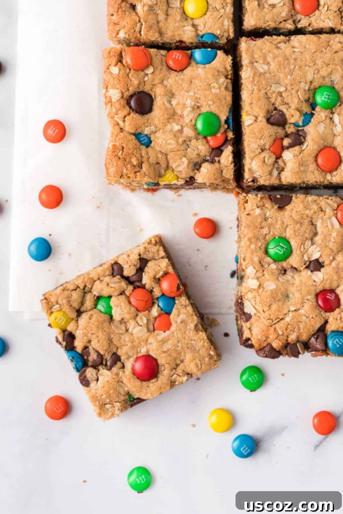 Everything-But-The-Kitchen-Sink Cookie Bars 2 Delicious Monster Cookie Bars cut into perfect squares, ready to serve and enjoy. A vibrant and appealing dessert for any occasion.