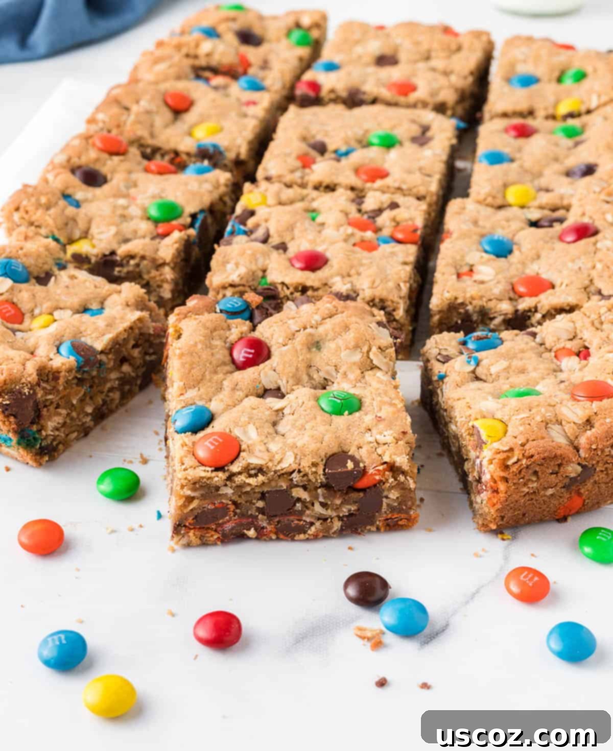 Everything-But-The-Kitchen-Sink Cookie Bars 15 A close-up view of multiple Monster Cookie Bars, showcasing their rich texture and abundant chocolate chips and M&M's, ready for sharing.