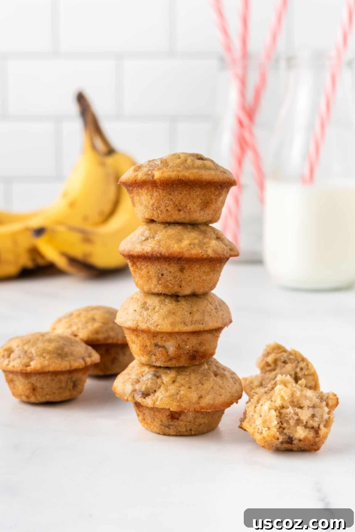 Bite-Sized Banana Muffins 16 A tower of golden-brown mini banana muffins with visible chocolate chips