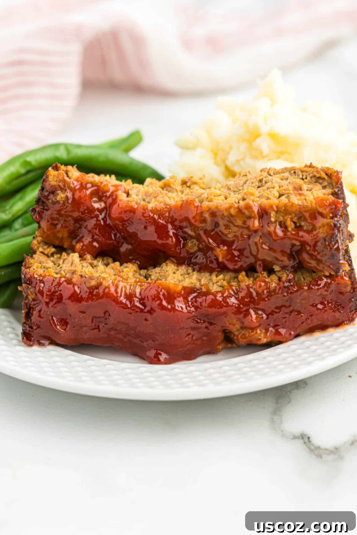 Hearty Plant-Based Meatloaf 2 Perfectly sliced vegetarian meatloaf with green beans and mashed potatoes on a plate, ready to be served