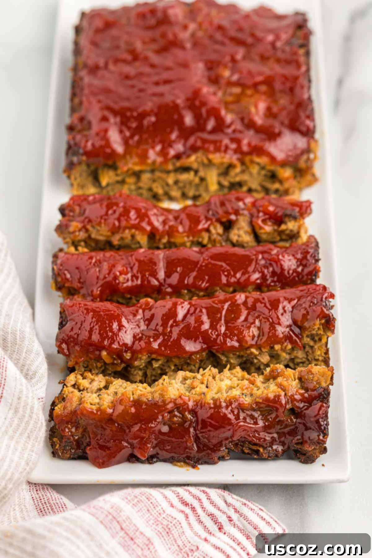 Hearty Plant-Based Meatloaf 17 Individual slices of vegetarian meatloaf garnished with fresh herbs, ready to be served