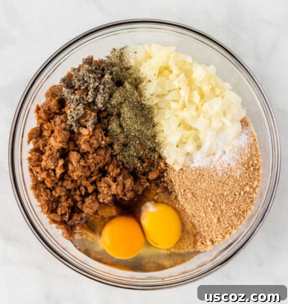 Hearty Plant-Based Meatloaf 8 All vegetarian meatloaf ingredients, including crumbles, eggs, and spices, in a large mixing bowl before combining