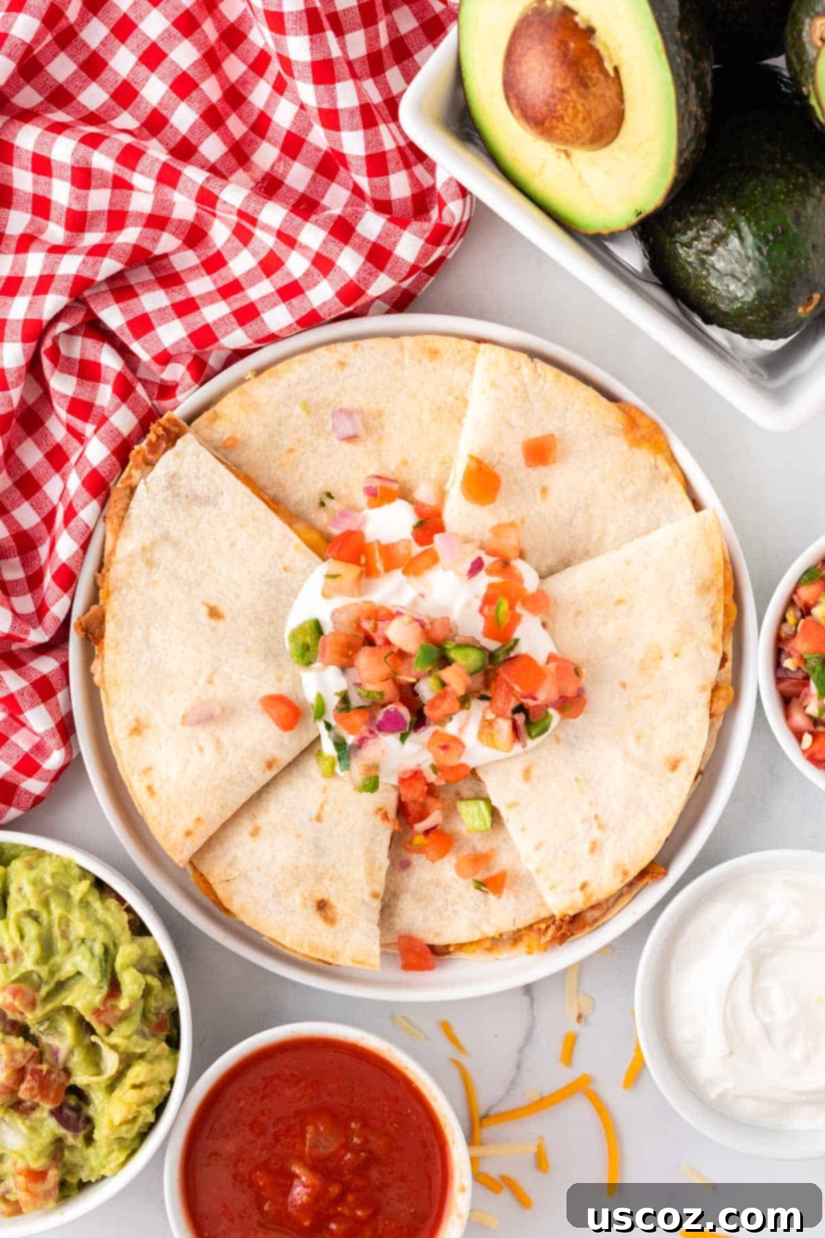 Air Fryer Quesadilla Perfection 2 quesadillas on a plate topped with sour cream and pico