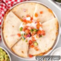 Air Fryer Quesadilla Perfection 11 quesadillas on a plate topped with sour cream and pico