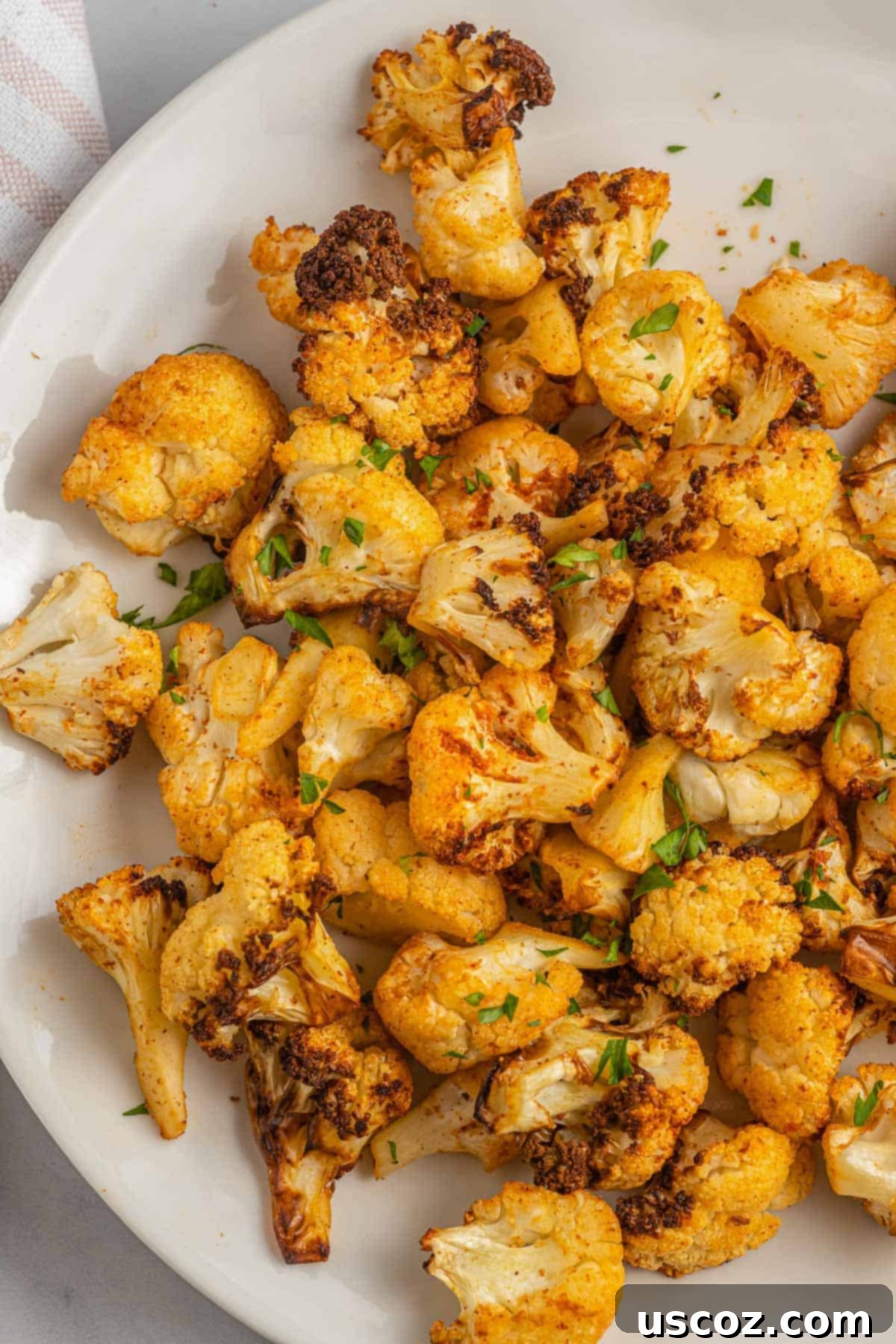 Crispy Air Fryer Cauliflower 2 Crispy roasted cauliflower on a plate, ready to be served as a healthy side dish.