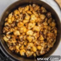 Crispy Air Fryer Cauliflower 10 Air fried cauliflower in the basket, showcasing its golden-brown crispiness.