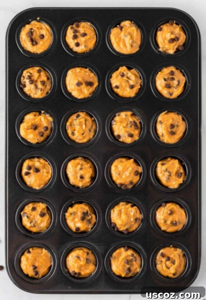 Bite-Sized Pumpkin Delights 14 A mini muffin tin filled with pumpkin chocolate chip batter, ready to go into the oven.