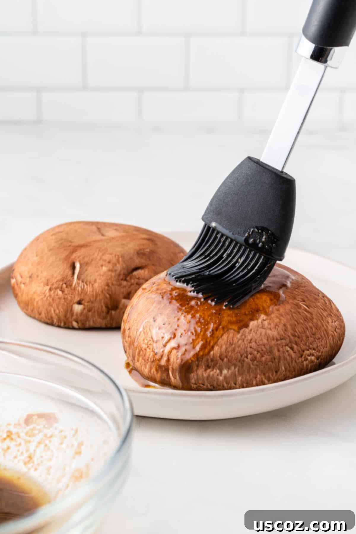Crispy Air Fryer Portobello Mushrooms 5 using a basting brush to cover the mushrooms in liquid