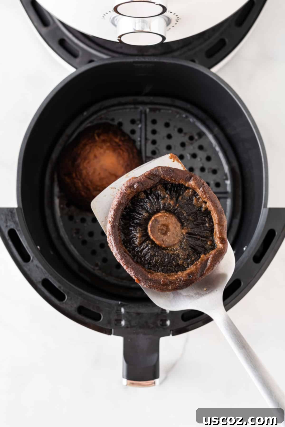 Crispy Air Fryer Portobello Mushrooms 8 taking a mushroom from the air fryer