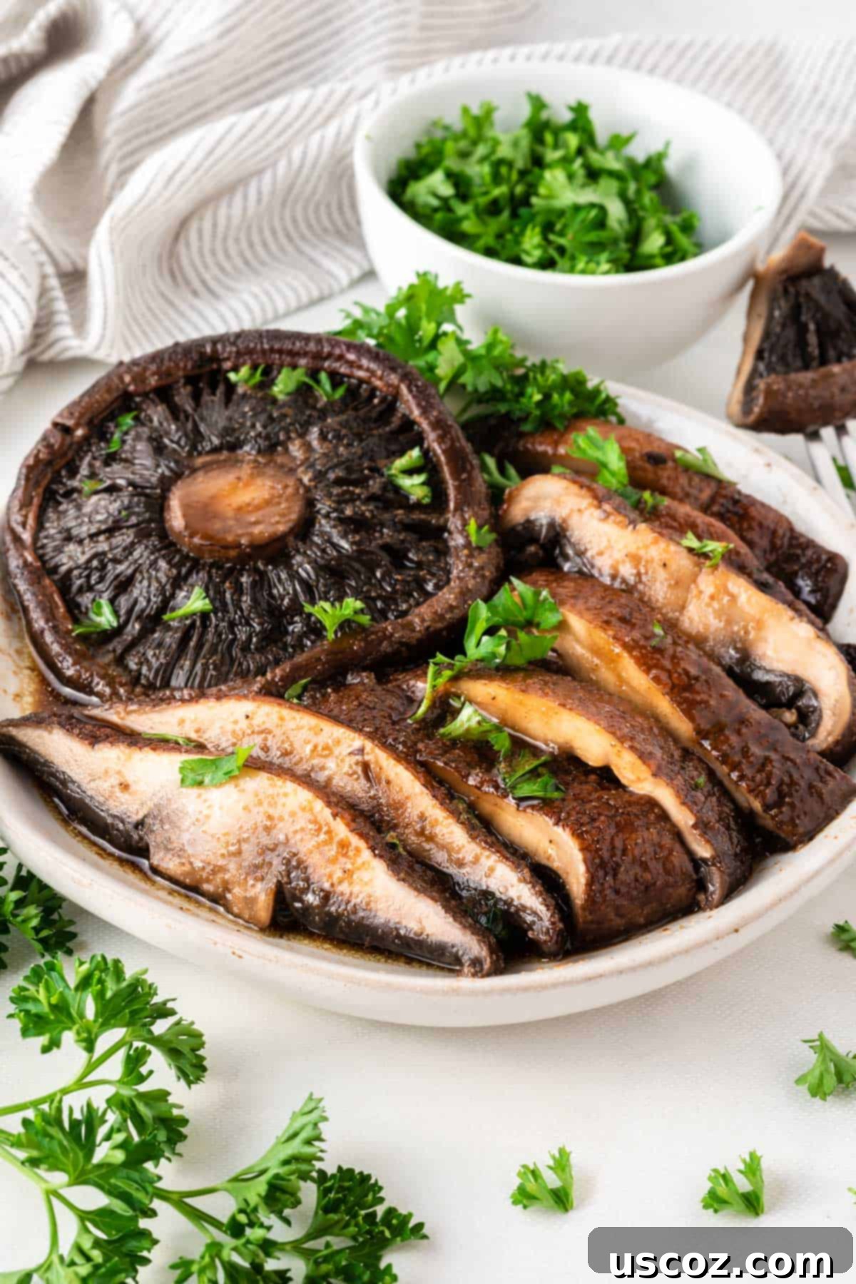 Crispy Air Fryer Portobello Mushrooms 9 portobello mushrooms cut into slices topped with parsley on a plate