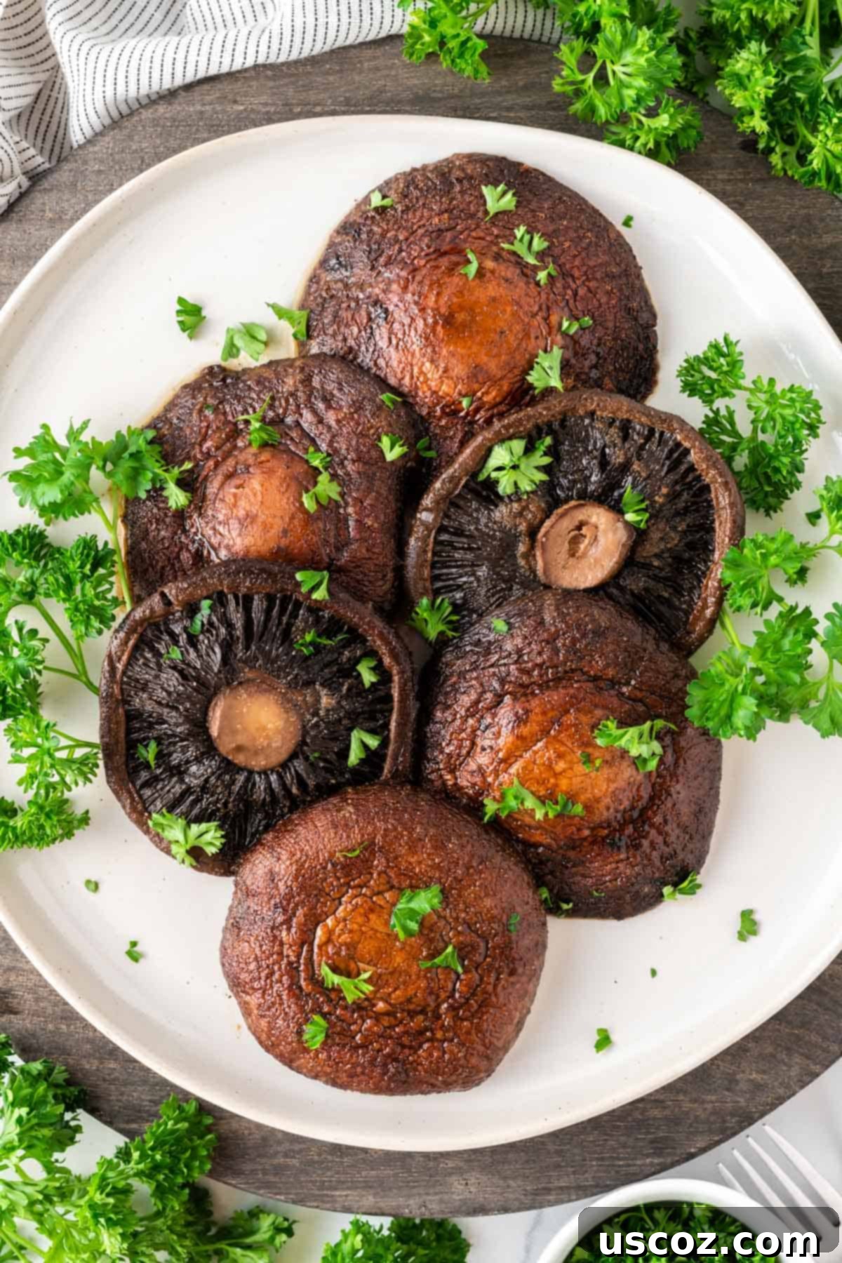 Crispy Air Fryer Portobello Mushrooms 10 portobello mushrooms topped with parsley on a plate