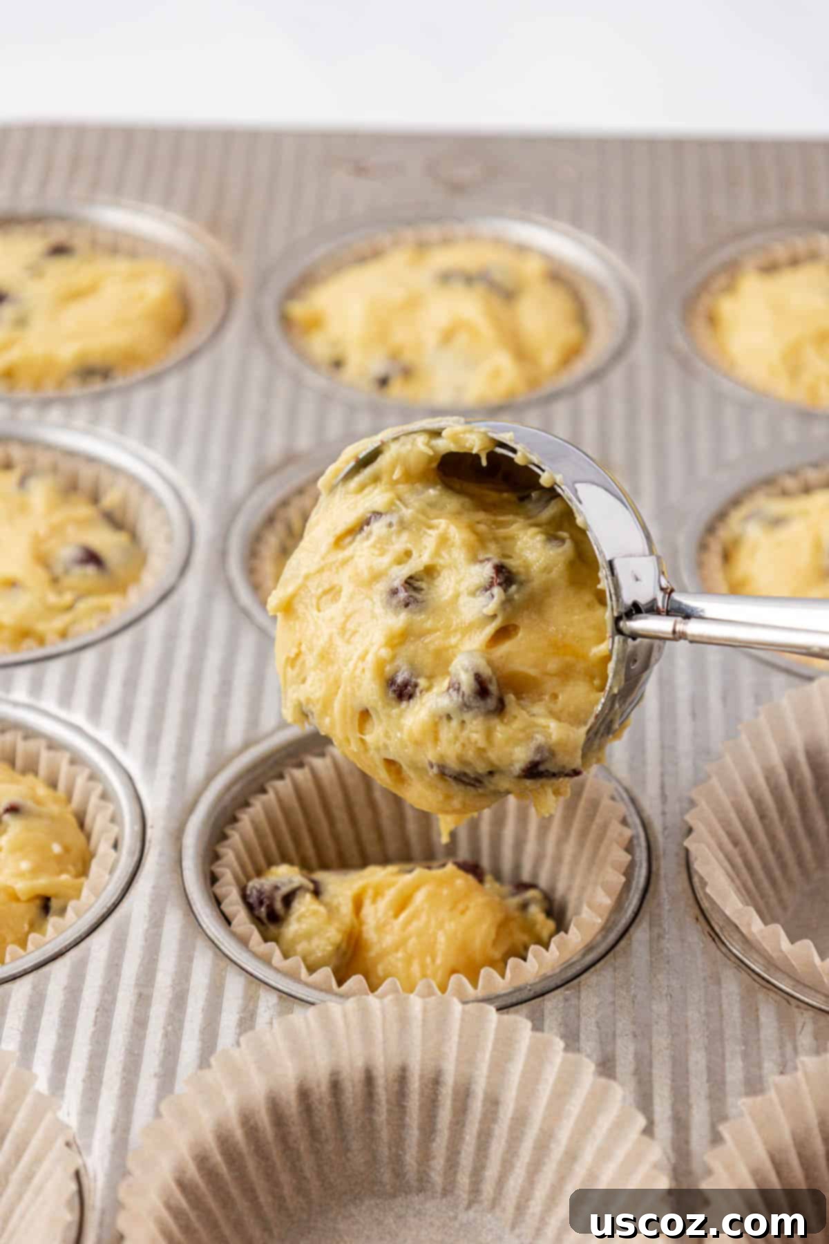 Bakery-Style Chocolate Chip Muffins from a Box 11 scooping batter into muffin liners