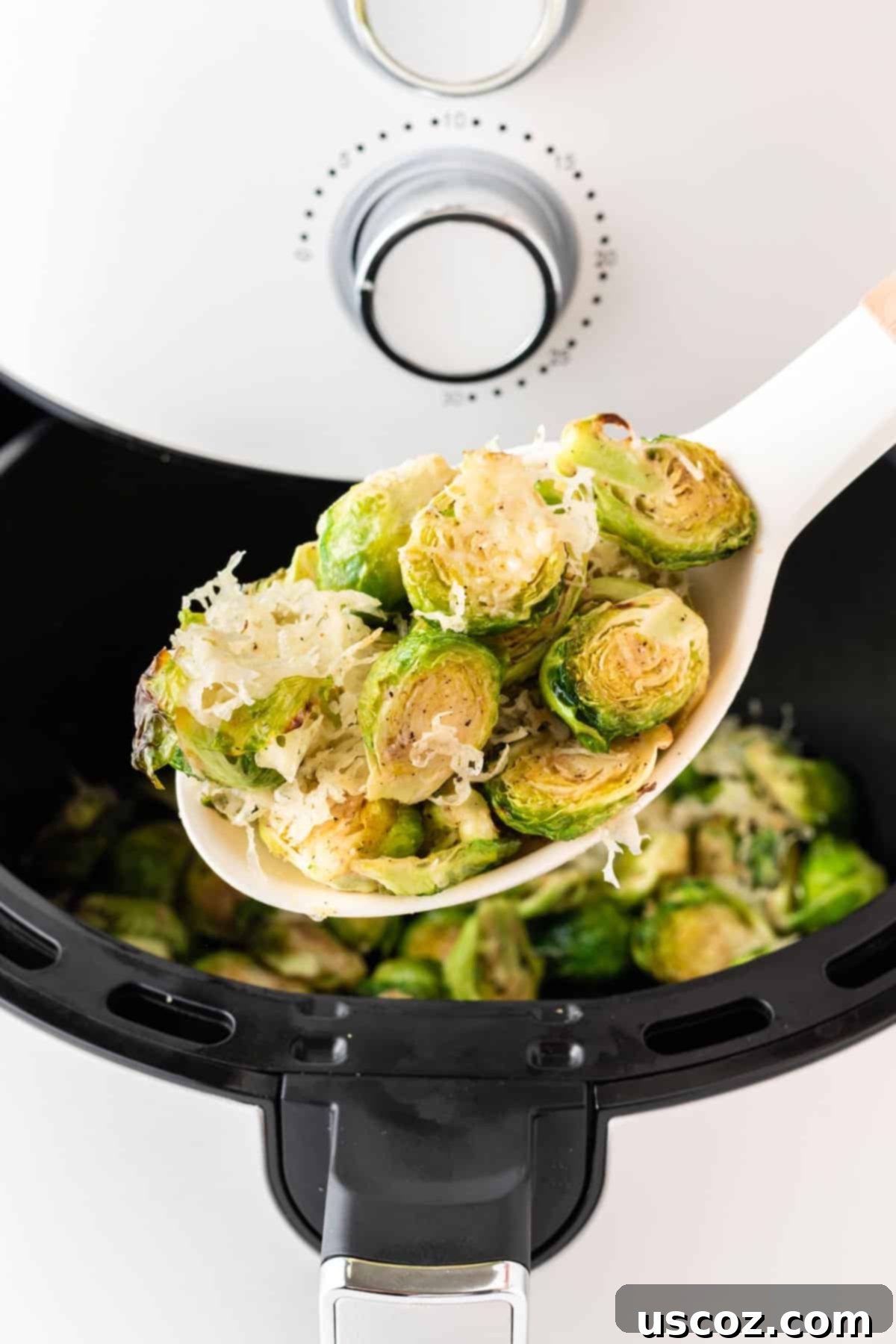 Crispy Air Fryer Brussels Sprouts 11 spoon holding a scoop of cheesy brussels sprouts