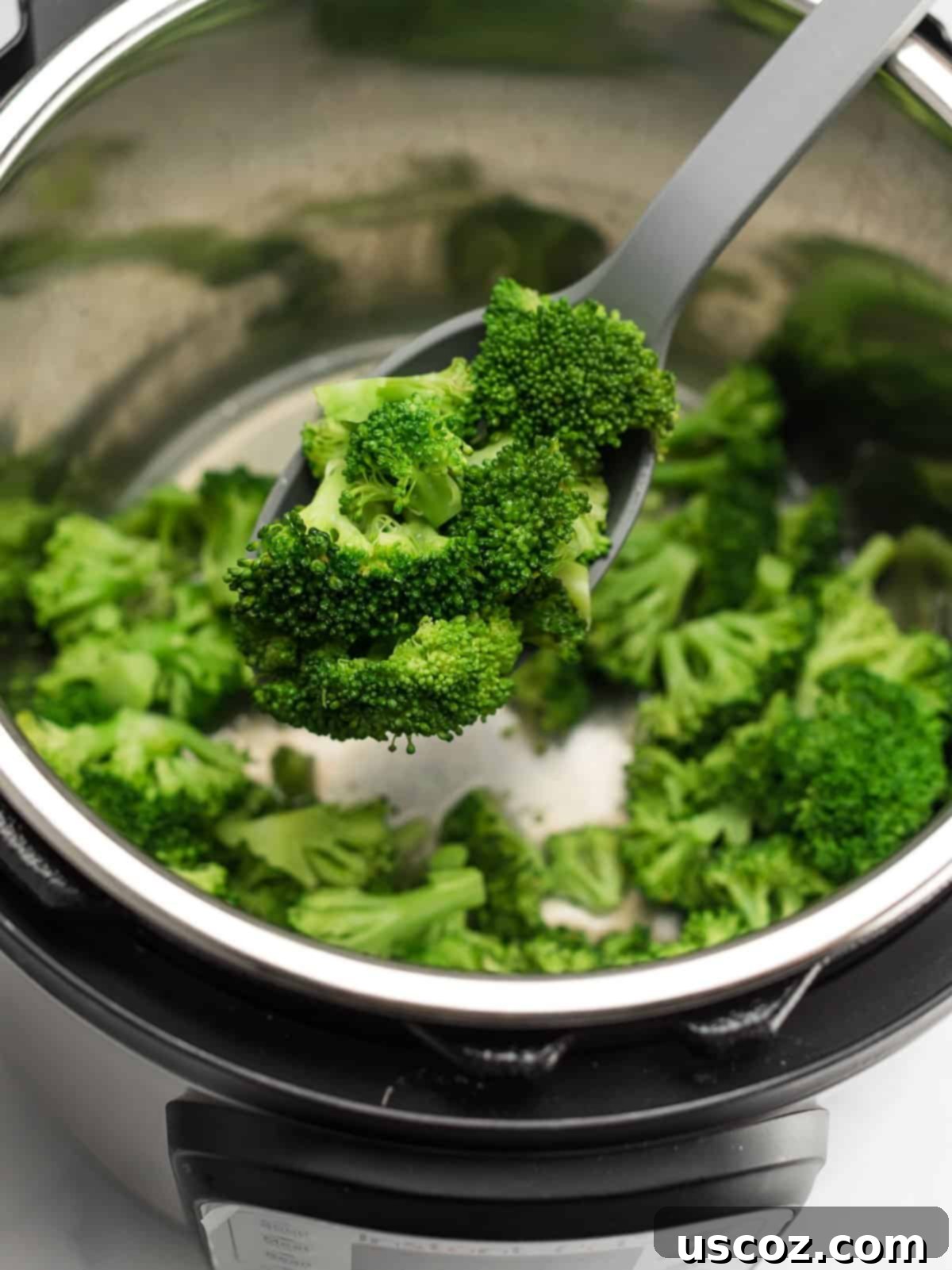 Foolproof Instant Pot Broccoli 5 spoon scooping broccoli from the instant pot