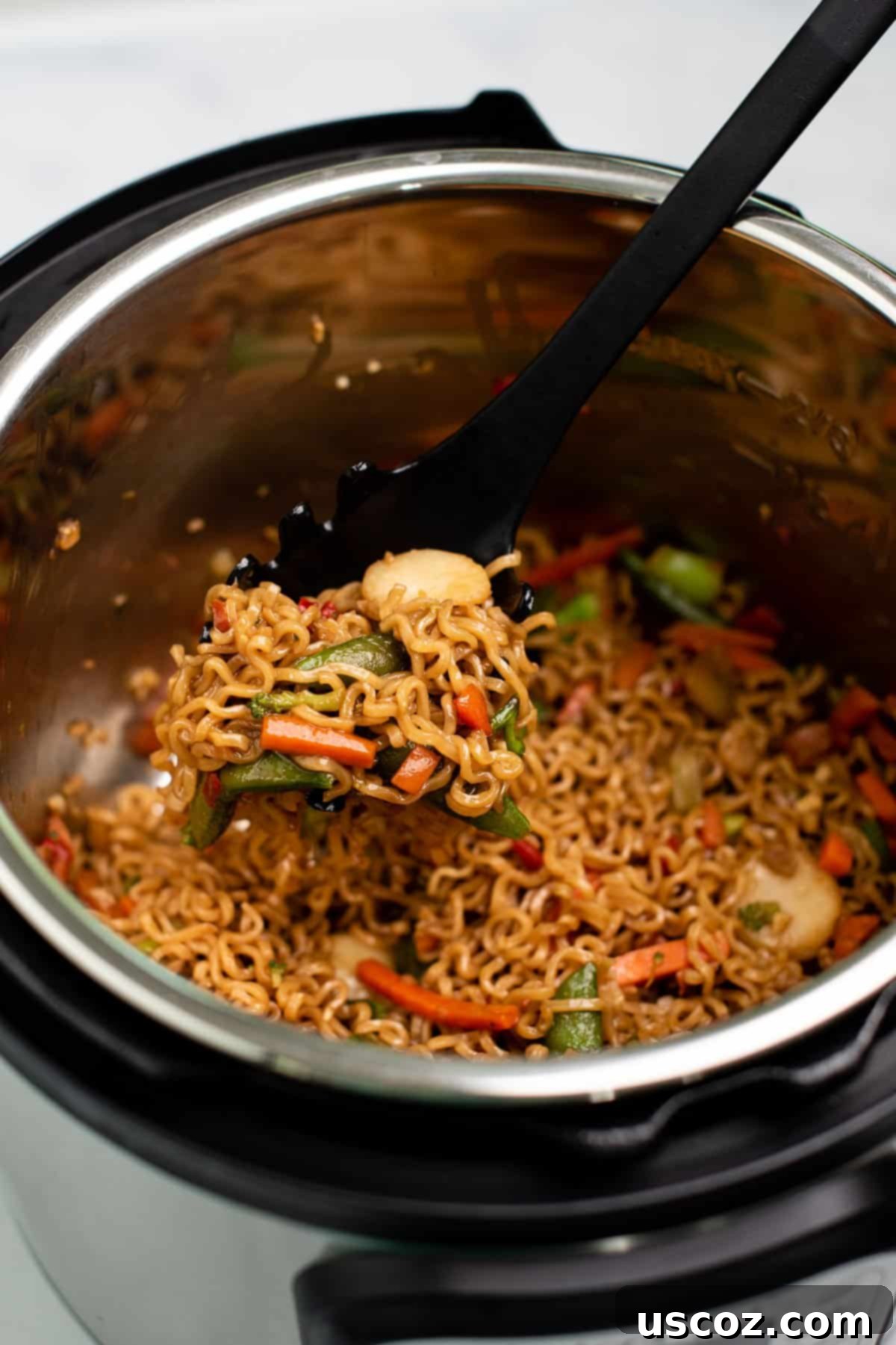 Effortless Instant Pot Stir Fry 2 taking a scoop of stir fry noodles from the instant pot