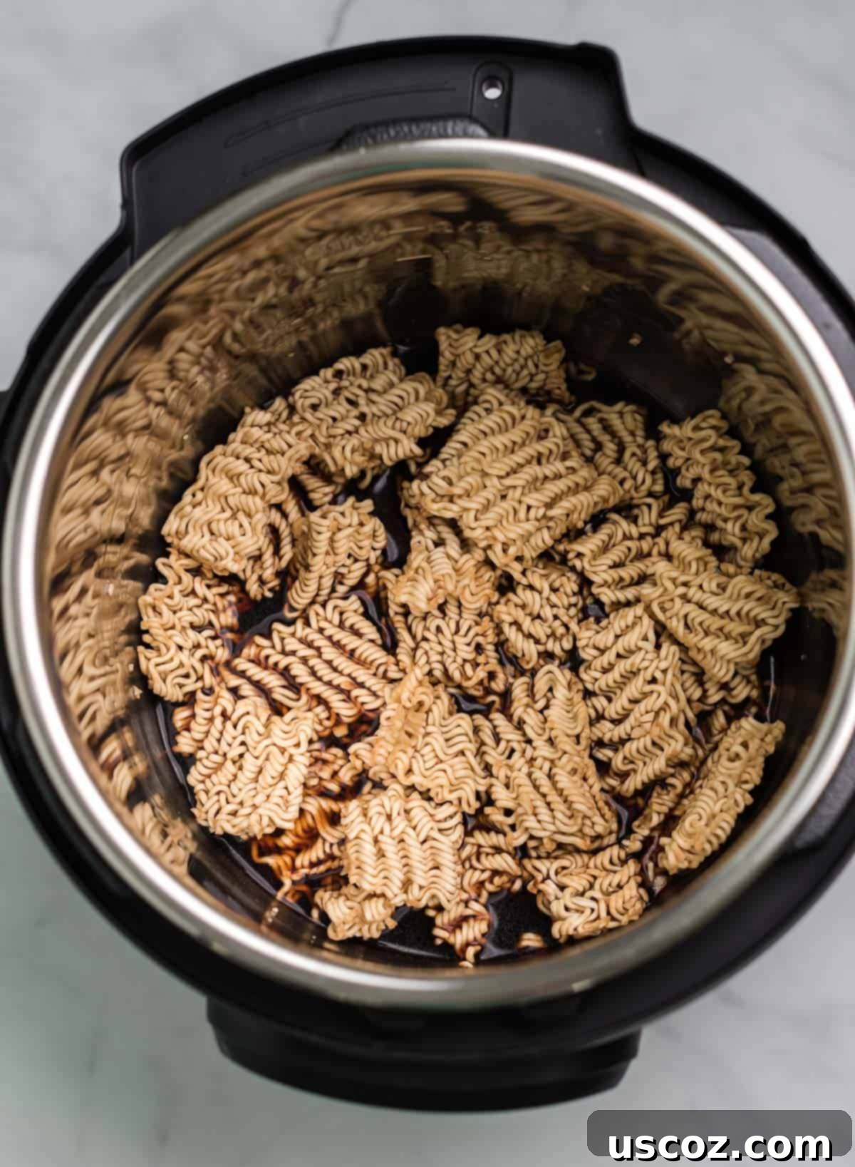 Effortless Instant Pot Stir Fry 5 adding soy sauce and vegetable broth to the ramen noodles