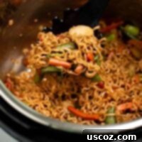 Effortless Instant Pot Stir Fry 10 taking a scoop of stir fry noodles from the instant pot
