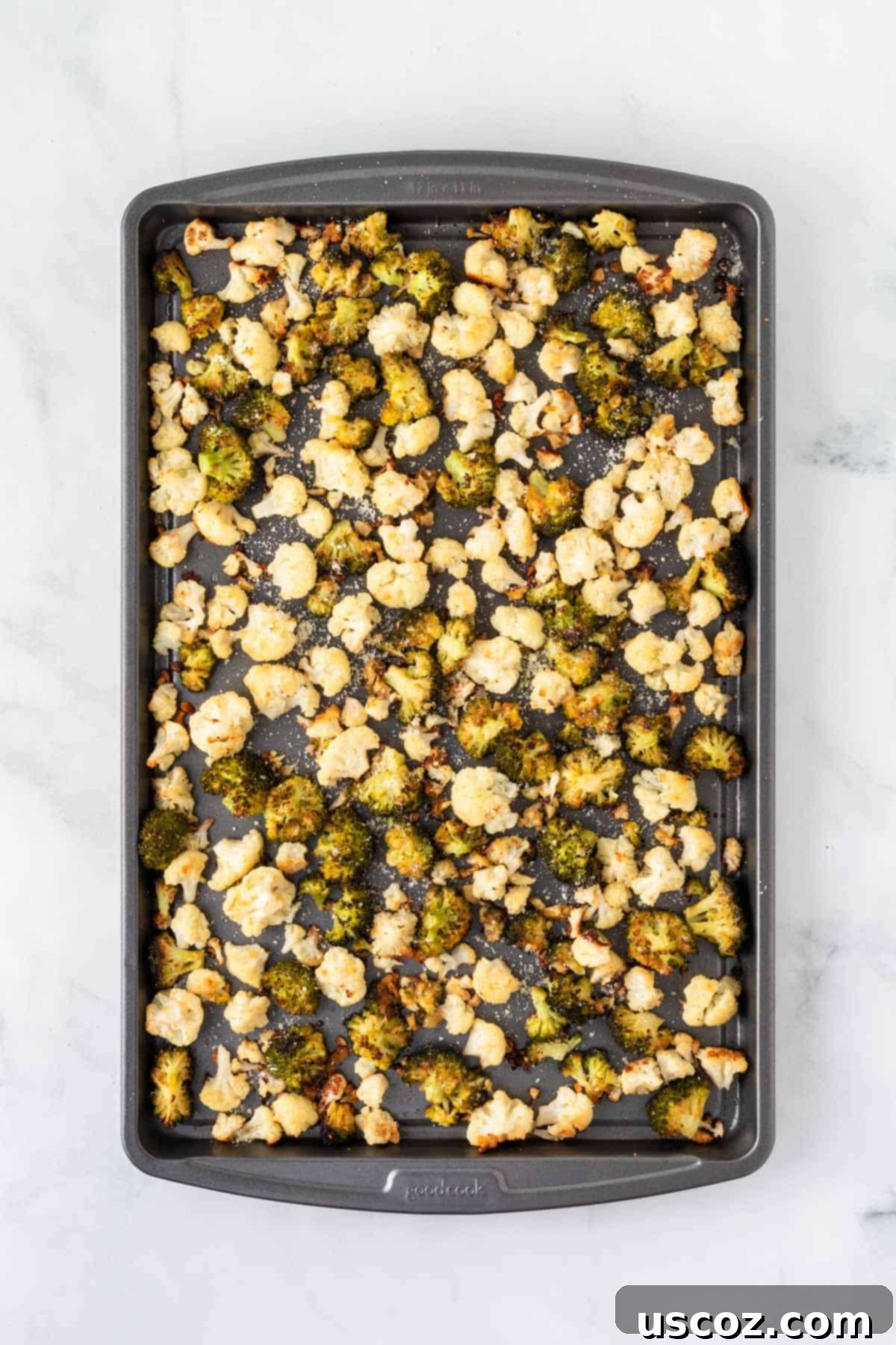 Golden Roasted Broccoli and Cauliflower 9 A large baking sheet filled with a generous portion of perfectly roasted broccoli and cauliflower, glistening and ready to be served as a healthy side dish.