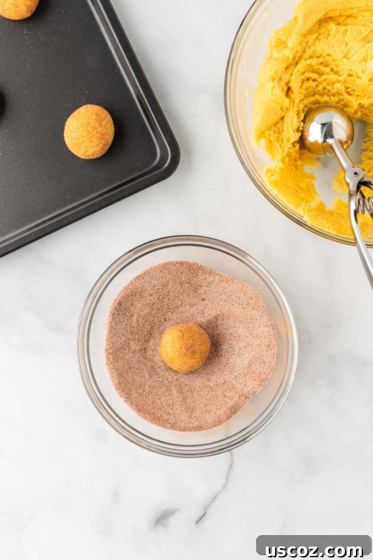Effortless Cake Mix Snickerdoodles 10 Rolling a ball of cake mix snickerdoodle dough in cinnamon sugar to coat it evenly